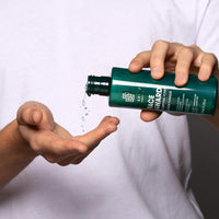 Man in t-shirt dispensing Face 4Ward Clarifying Toner into palm of hand