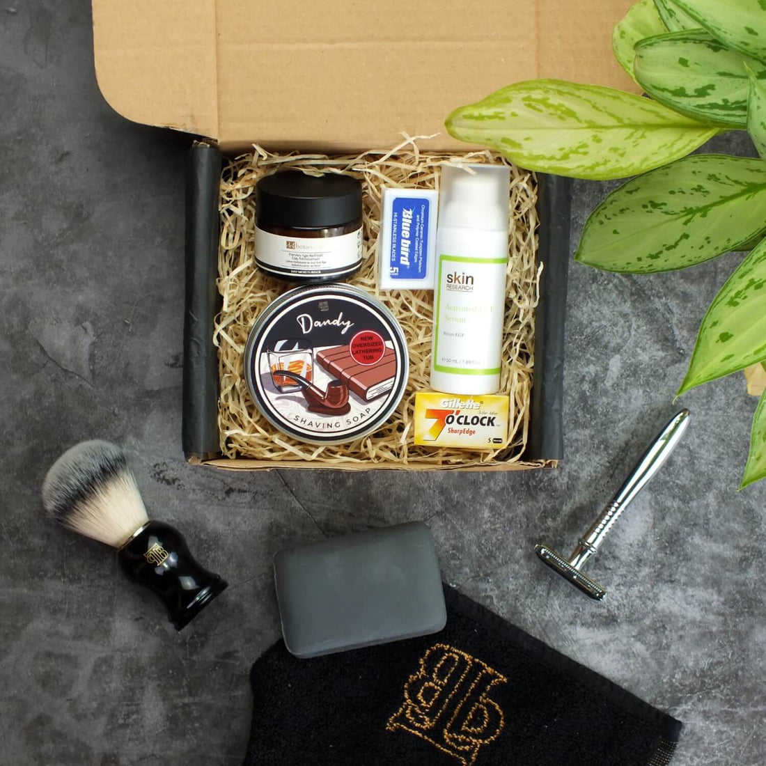 top down shot of our complete shaving kit with July/aug '23 contents featuring the Dandy shaving soap, parsley age refresh moisturiser, activated EGF serum, premium safety razor and synthetic hair shaving brush