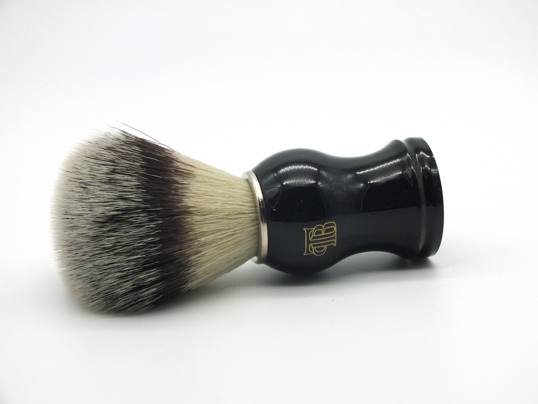 The Personal Barber Synthetic Hair Shaving Brush  lying on its side. Silvertip nylon hairs